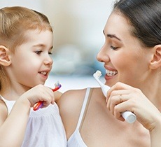 Mother and child brushing teeth