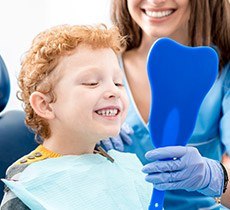 Little boy looking at smile in mirror