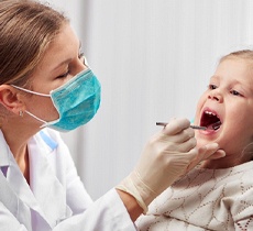 A little girl having her teeth looked at by a pediatric dentist