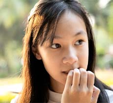 Girl chewing nails headed for kid’s chipped tooth in Garland 