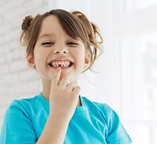 Girl smiling after tooth extraction in Garland