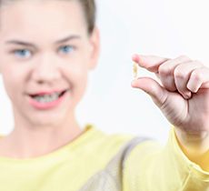 Young child holding an extracted tooth