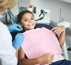 Happy, smiling child getting ready for dental treatment