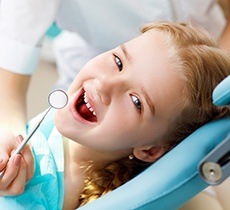 Smiling young girl in dental chair