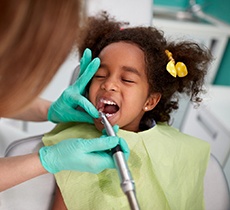 Dentist cleaning child’s teeth