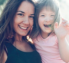 Mother holding her smiling daughter