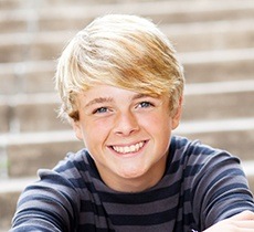 Smiling teen boy on concrete steps