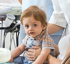 Little boy in parent's lap at dentist
