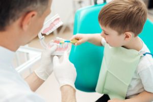 Small boy at the dentist learning about his teeth.