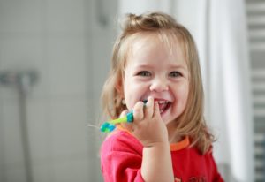 little girl smiling with toothbrush