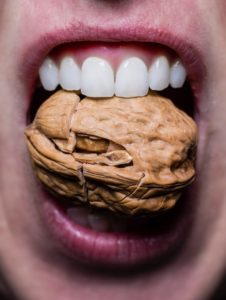 close up of mouth cracking a nut