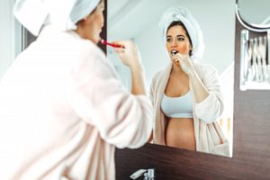 Pregnant woman brushing her teeth