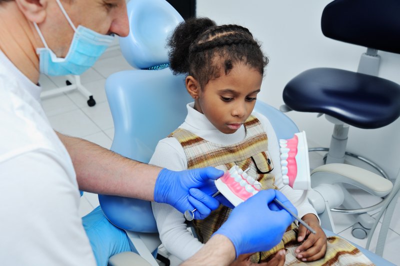 a young child listening to their dentist 