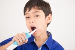 child using electric toothbrush 