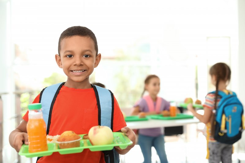 little boy holding a school lunch tray