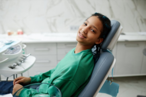 Teenager sitting in a patient’s chair at the dentist’s office looking at ease